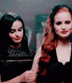 two women are standing next to each other in a room .