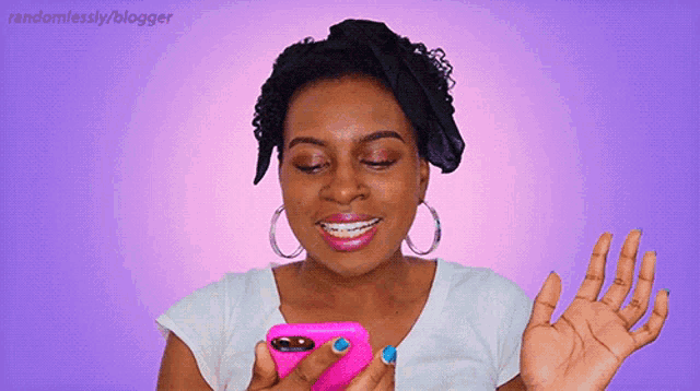 a woman in a white shirt is holding a pink cell phone in her hand