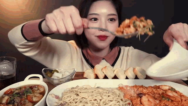 a woman eating spaghetti with a fork and knife