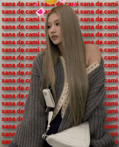 a woman with long blonde hair wearing a grey sweater and a white purse