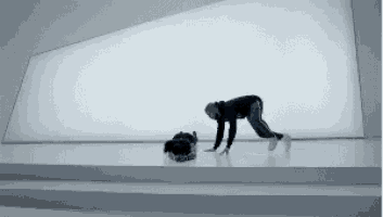 a person is crawling on a white surface in front of a white wall