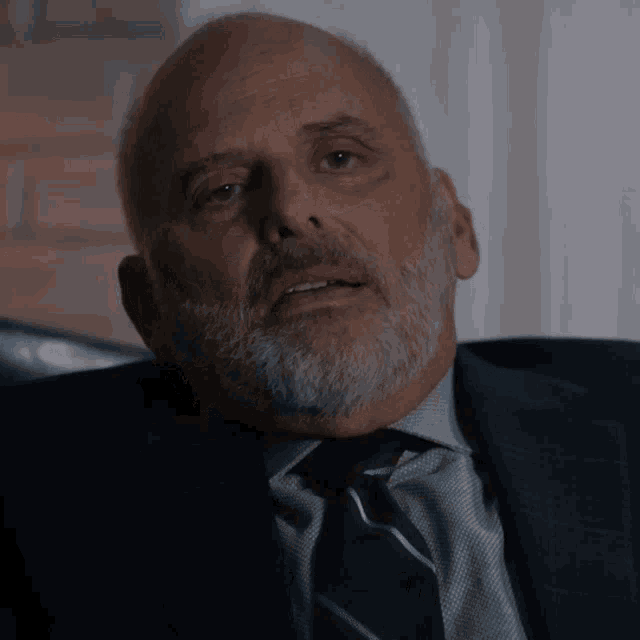 a man with a beard wearing a blue suit and tie