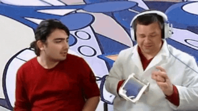 two men wearing headphones are talking to each other in front of a cartoon background