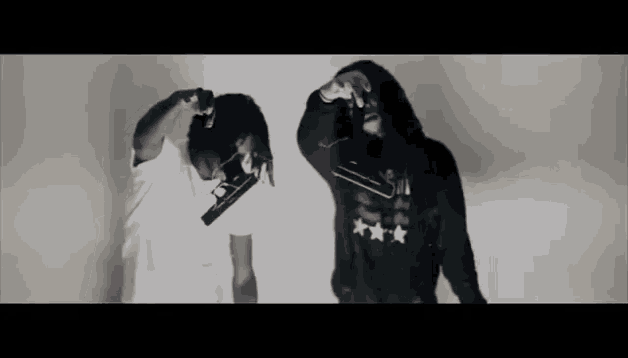 two men in hoodies are holding guns in their hands