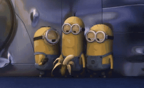a group of minions are standing next to each other eating bananas .