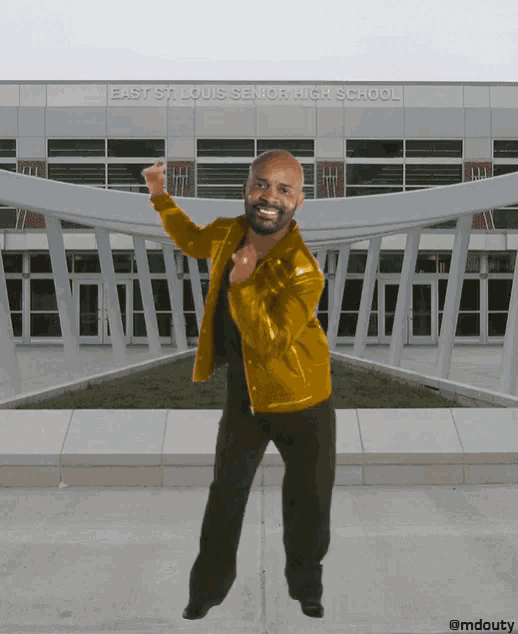 a man is dancing in front of a building that says east st. louis senior high school