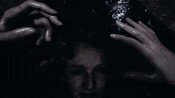 a man 's head is being touched by two hands