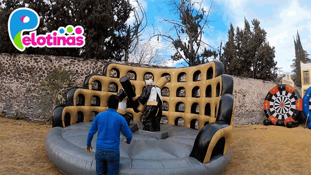 a man in a blue shirt stands in front of a large inflatable item that says pelotinas on it