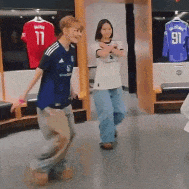 a man and a woman are dancing in a locker room .