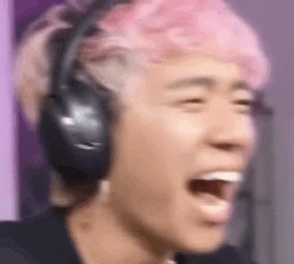a close up of a person wearing headphones and laughing with their mouth open .