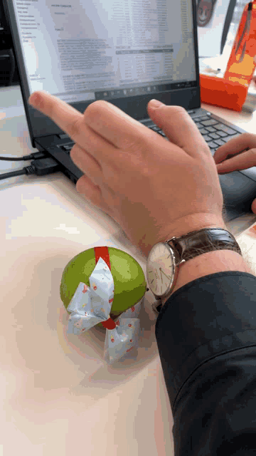 a man wearing a watch points to a lime with a bow on it