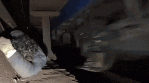 a person is laying on the ground in a dark room while a train is going by .