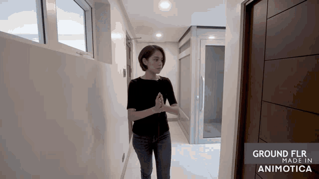 a woman walking down a hallway with the words ground flr made in animotica on the bottom right