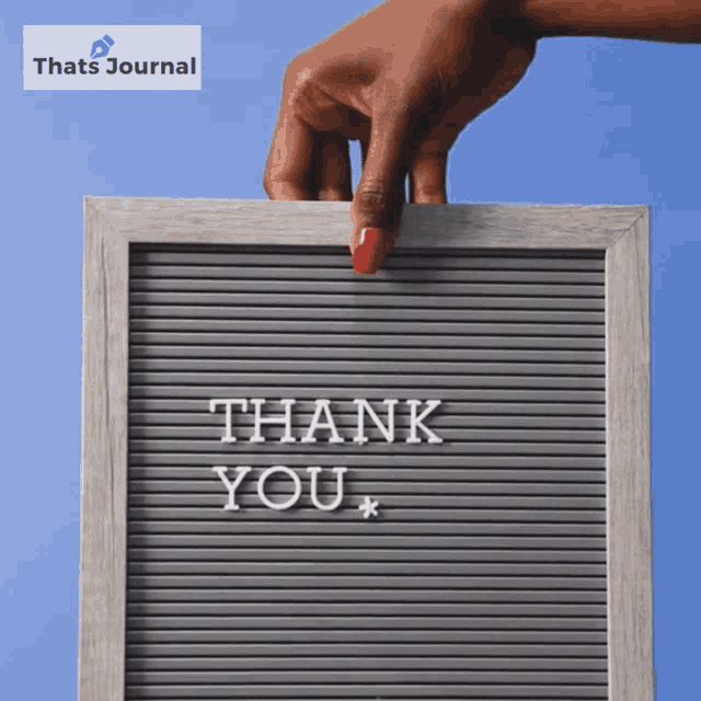 a person holding a sign that says thank you on it