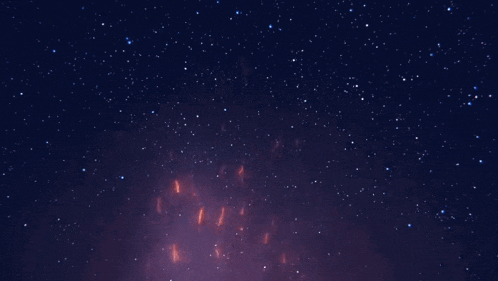 a dark blue sky with lots of stars and a purple glow