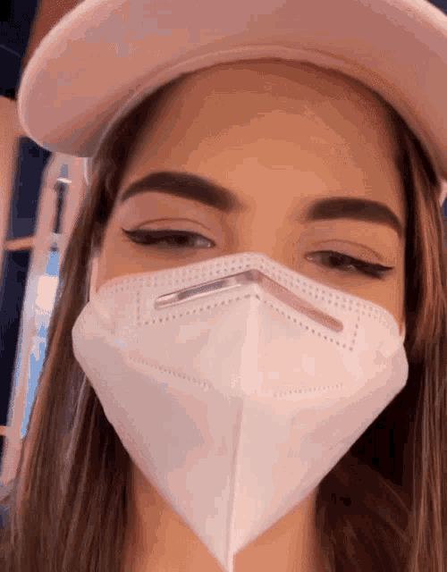 a woman wearing a pink hat and a white mask