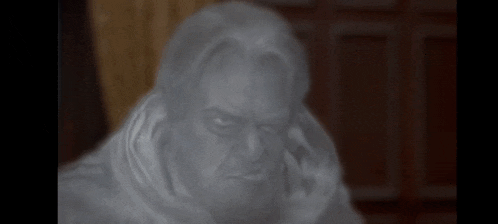 a statue of a man with a scarf around his neck is looking at the camera .
