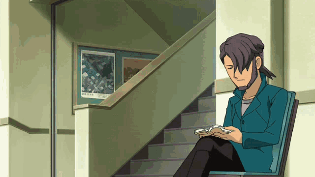 a man sits in a chair in front of a staircase with a poster on the wall that says ' network '