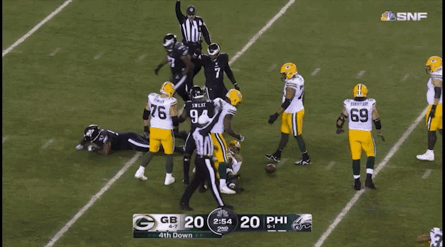 a green bay packers player is laying on the ground during a football game