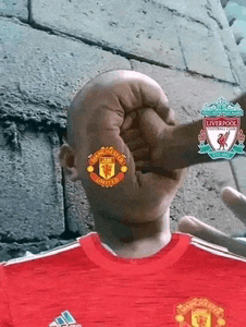 a man wearing a red shirt with manchester united on his head