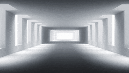 a very long hallway with a lot of windows and a light at the end