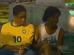 a man wearing a yellow shirt with the number 10 on it sits next to a woman