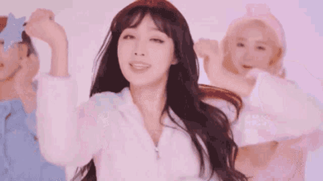 a woman in a white jacket is dancing in front of a group of girls .