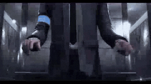 a man in a suit is standing in an elevator with his hands on the buttons .
