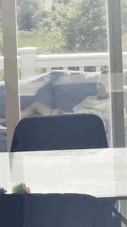a man is laying on a couch in front of a glass door