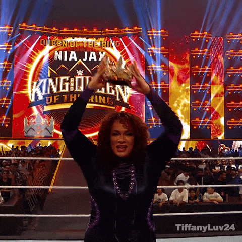 queen of the ring nia jay holding a trophy in front of a crowd