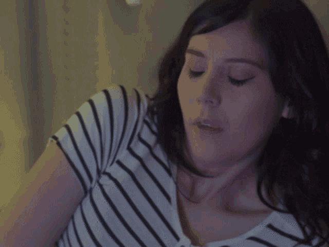 a woman in a striped shirt is looking down at something