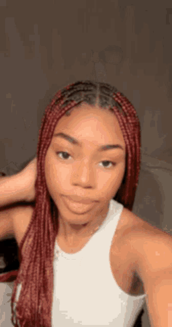 a woman with red braids is taking a selfie with her phone .