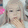 a blurry picture of a woman 's face with blonde hair and a white shirt .
