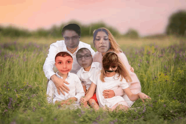 a family is sitting in a field of purple flowers with their faces cut out