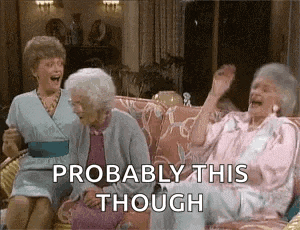 three older women are sitting on a couch laughing and talking .