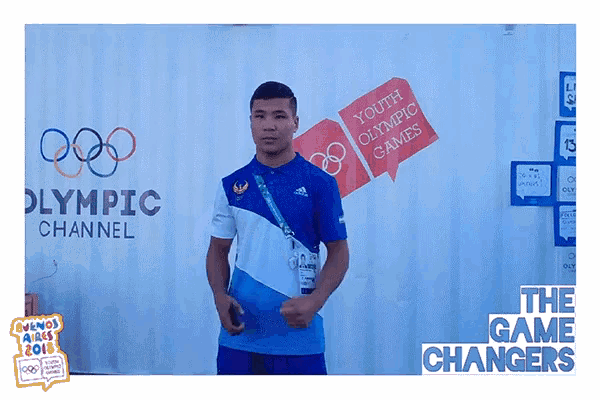 a man stands in front of an olympic channel sign