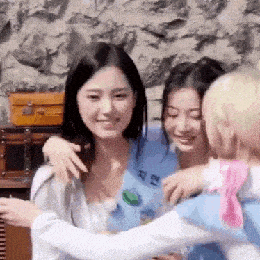 a group of young women are hugging each other and smiling .