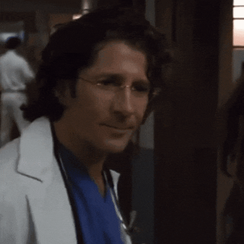 a man in a white coat is pointing at something
