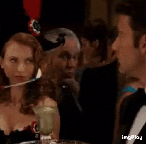a man in a tuxedo is talking to a woman in a corset .