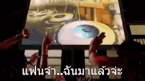 a group of people are clapping in front of a large screen that says ' แฟน จ้า ' on it
