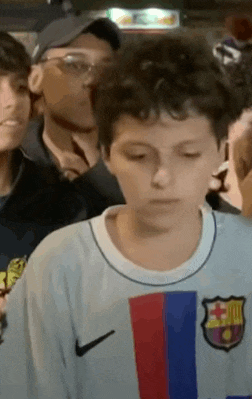 a young boy wearing a nike shirt with a fcb logo on it