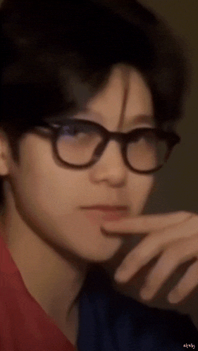 a close up of a person wearing glasses and making a funny face .