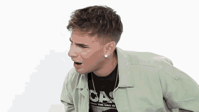 a young man wearing a green jacket and a black t-shirt that says the main 101