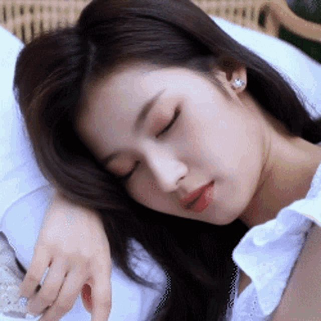 a close up of a woman sleeping on a pillow