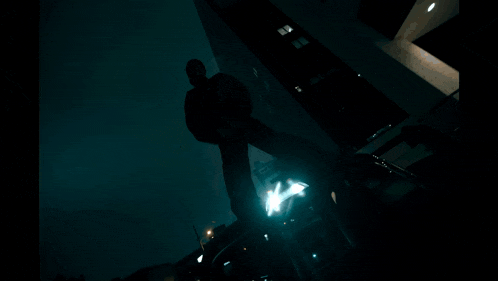 a man in a black jacket stands in the dark