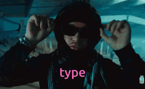 a person wearing a hood and sunglasses has the word type written on their shirt