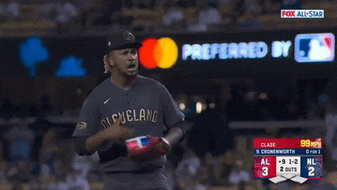 a baseball player wearing a cleveland jersey stands in front of a fox all star banner