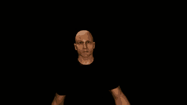 a bald man with a tattoo on his arm is giving a fist bump in the air .