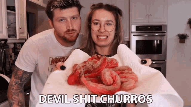 a man and a woman holding devil shit churros in their hands
