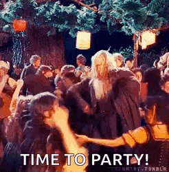a group of people are dancing in a forest and a man is holding a woman 's hand .